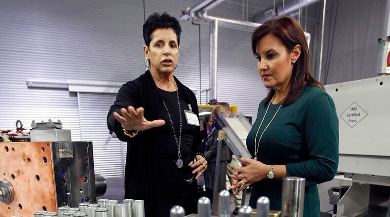 Karin Gaiser, left, president and chief executive of Eco Groupe, describes plastic injection molds to Ohio Lt. Governor Mary Taylor in a plant tour in 2014. This week, the company’s former home on Ventor Avenue sold for $1 million. TY GREENLEES / STAFF