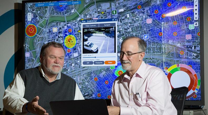 In this 2016 file photo, Larrell Walters, then-Universal Technology Corp’s senior director of commercial products, left, and company CEO Joe Sciabica are reviewing a law enforcement data mapping system called Footprint. TY GREENLEES / STAFF