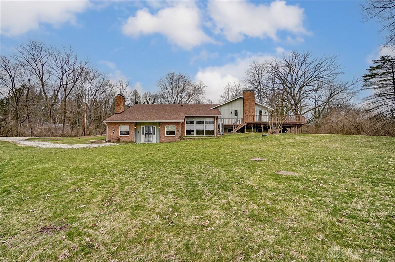 The rear of the home has a wrap around wood deck with railings and a walk out from the family room.