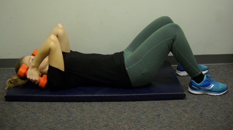 Slowly lower dumbbells until they lightly touch the shoulders.