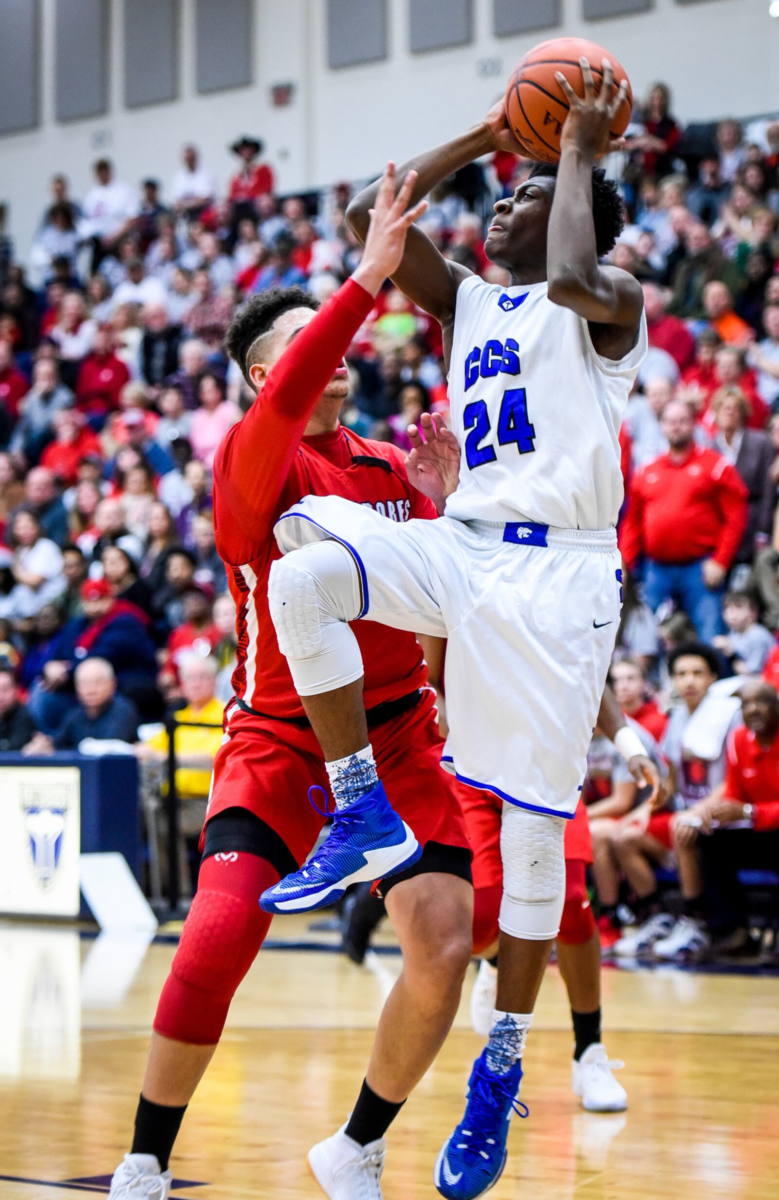 Cincinnati Christian’s Cameron Rogers (24) drives on Lima Perry’s Kobe Glover during Friday night’s Division IV regional final at Fairmont’s Trent Arena.  NICK GRAHAM/STAFF
