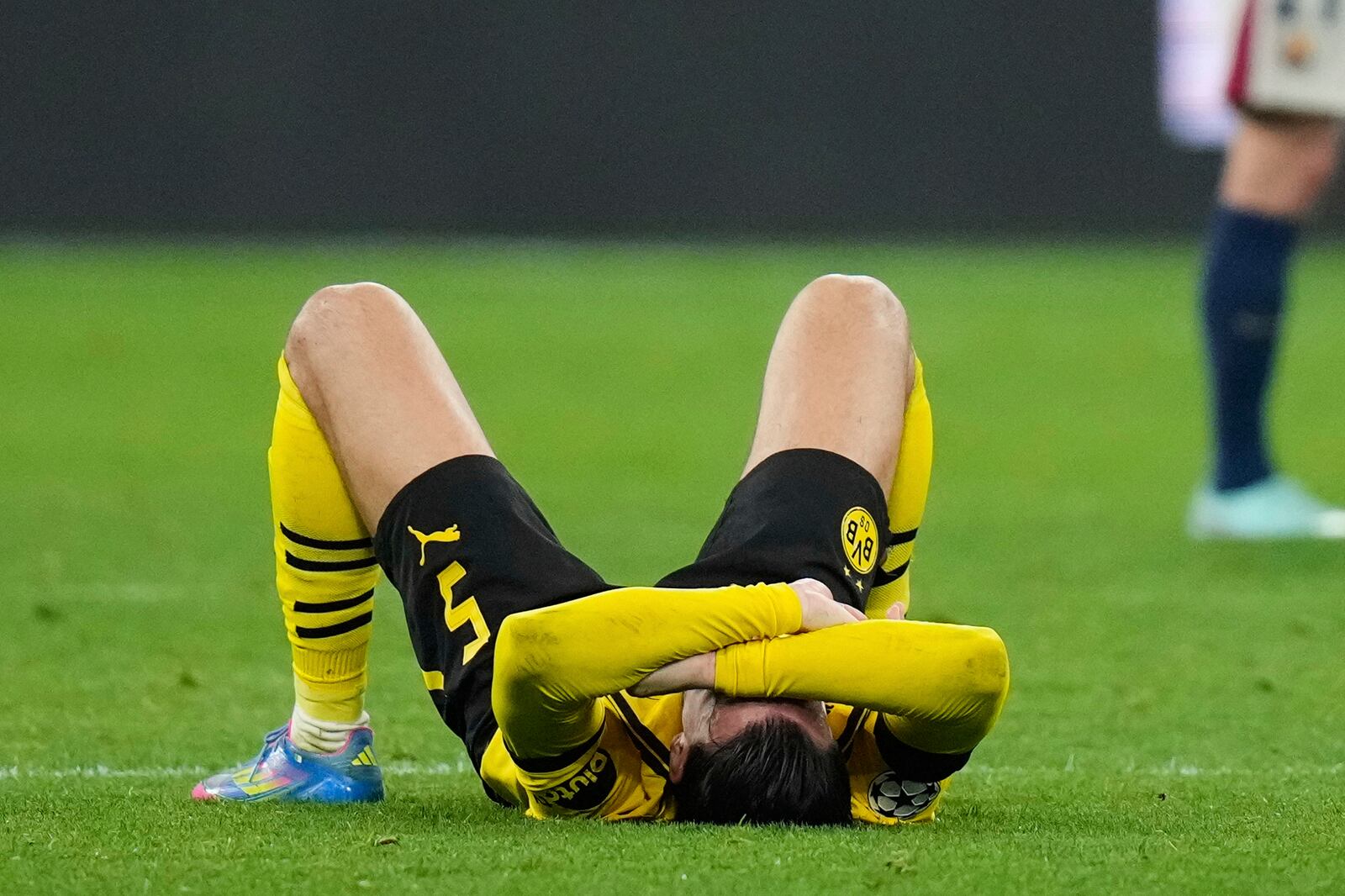 Dortmund's Ramy Bensebaini reacts at the end of the Champions League quarterfinals second leg soccer match between Borussia Dortmund and Barcelona, at the Signa-Iduna Park in Dortmund, Germany, Tuesday, April 15, 2025. (AP Photo/Matthias Schrader)
