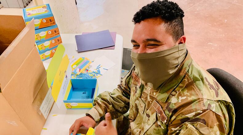 Senior Airman Kwame Robertson of Wright-Patterson Air Force Base’s National Air and Space Intelligence Center builds “Love Them Out Loud” kits during the Dec. 18 volunteer event benefiting the Dayton Metro Library and early childhood literacy. CONTRIBUTED PHOTO