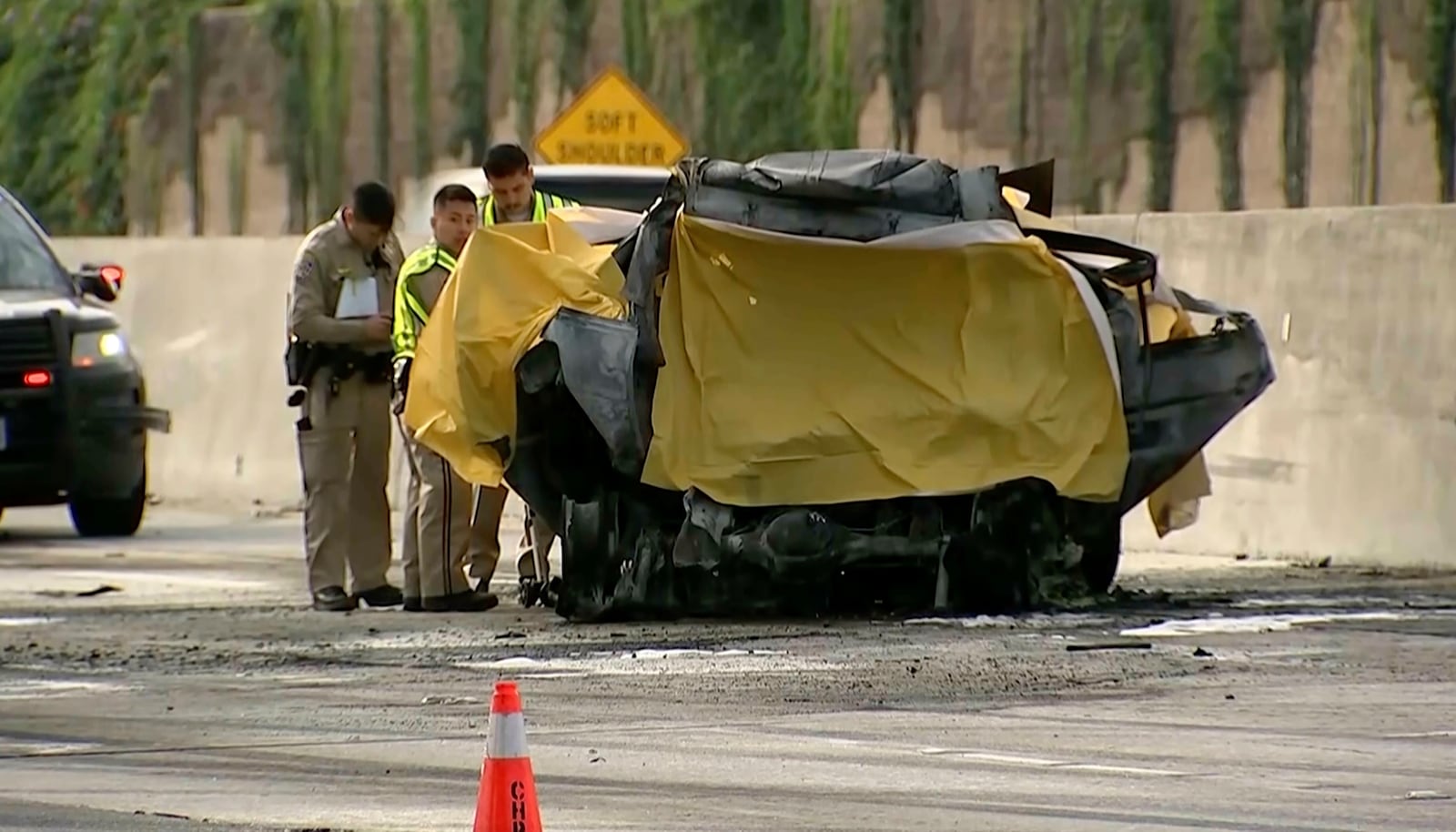 This image provided by KABC-TV shows police working near a crashed sport utility vehicle after it collided with a tour bus, Sunday, May 11, 2025 in Los Angeles. (KABC-TV via AP)