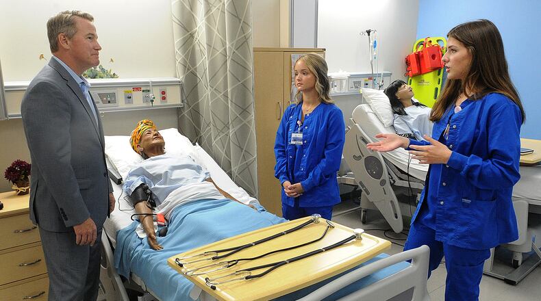 Greene County Career Center student Presley Baxter explains details of GCCC's health sciences classes to Ohio Lt. Gov. Jon Husted on Thursday 9, 2024, as fellow student Lilly Willmann assists. MARSHALL GORBY\STAFF