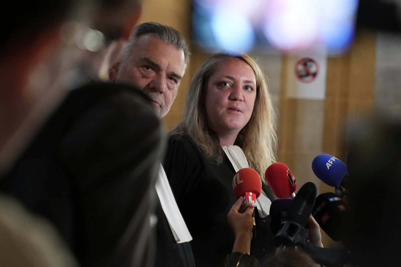Franck Berton, left, and Chloe Arnaux, lawyers for Aomar Aït Khedache, one of the men accused in the 2016 armed robbery of Kim Kardashian, answer reporters after the verdict in the trial of Kim Kadashian heist, Friday, May 23, 2025 in Paris. (AP Photo/Christophe Ena)