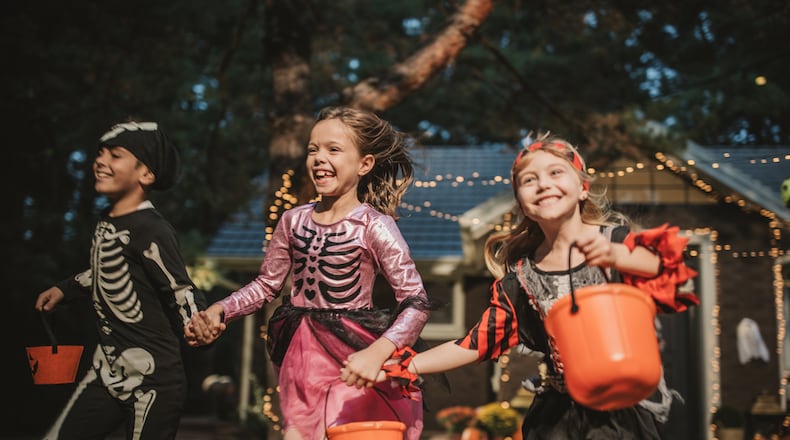 Check out the hours for trick-or-treat in your area. Pictured are kids trick or treating during Halloween. SVETIKD/ISTOCK