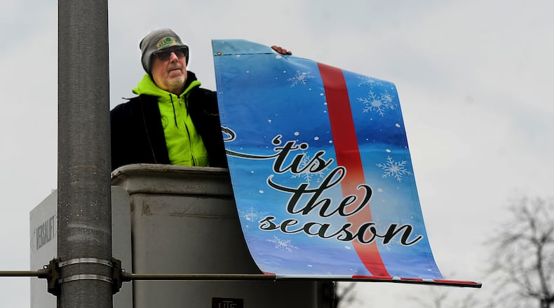 City of Oakwood employee Joel Blake takes down the holiday banners on Far Hill Ave. Tuesday Jan. 10, 2023. MARSHALL GORBY\STAFF