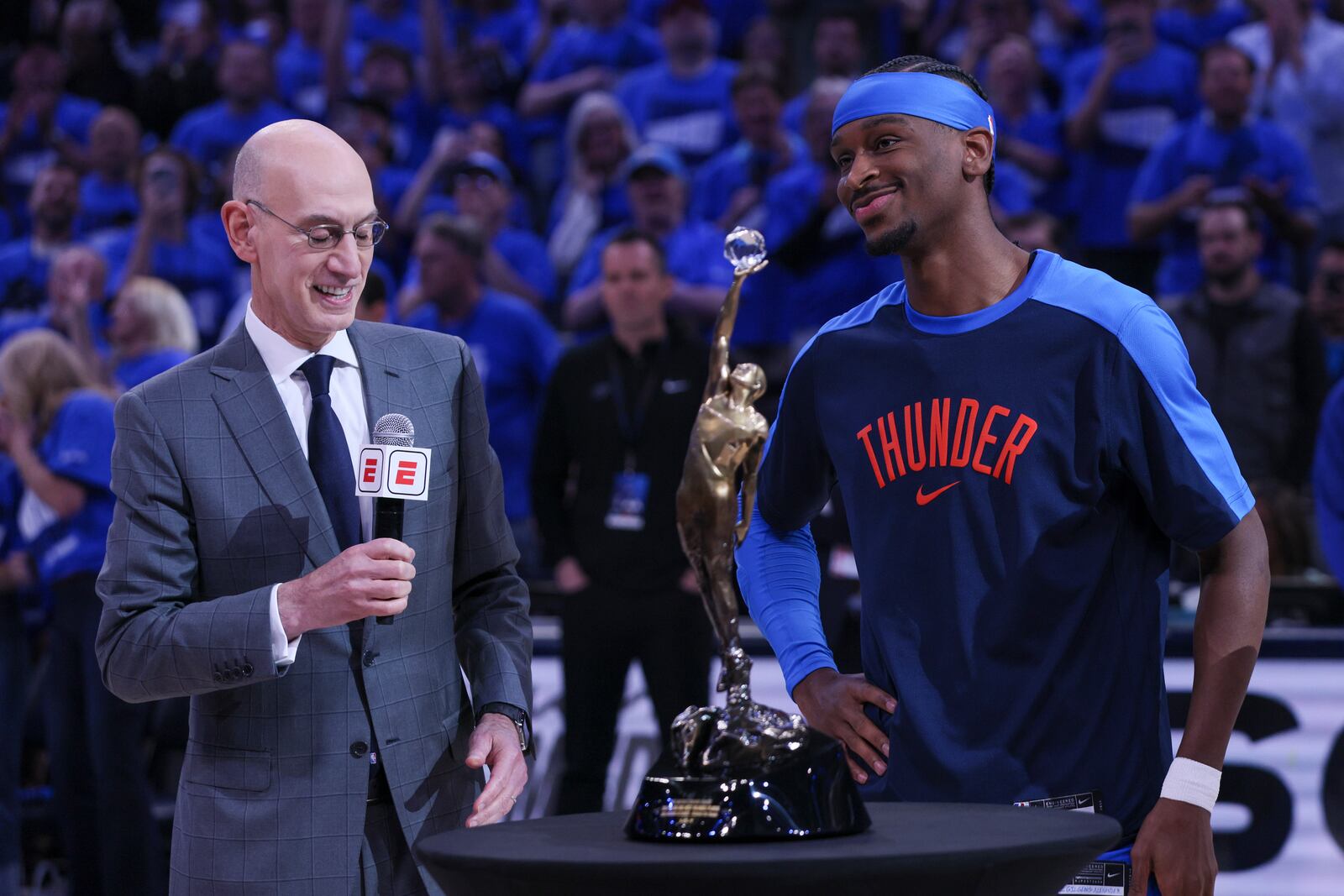 NBA commissioner Adam Silver, left, presents the Michael Jordan Most Valuable Player trophy to Oklahoma City Thunder guard Shai Gilgeous-Alexander prior to Game 2 of an NBA basketball Western Conference Finals playoff series between against the Minnesota Timberwolves Thursday, May 22, 2025, in Oklahoma City. (AP Photo/Nate Billings)