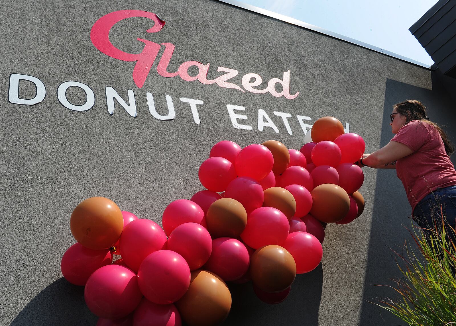 Blake Roysdon, owner of BNR Balloons, adds her touch of flare Friday, July 23, 2021 to the new Glazed Donut Eatery in Xenia. MARSHALL GORBY\STAFF