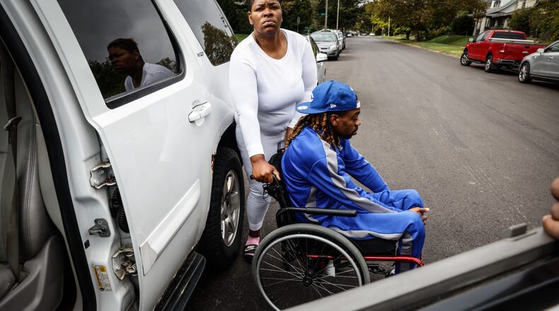 Terri Owensby, left, helps her brother, Clifford Owensby, out of his vehicle Monday Oct. 4, 2021. Clifford Owensby said he is a paraplegic and Dayton police pulled him out of his vehicle during a traffic stop. JIM NOELKER/STAFF