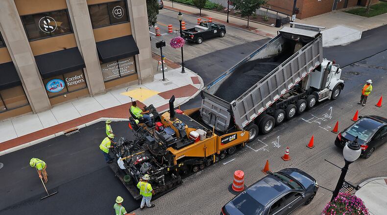 In this file photo, a crew from Valley Asphalt was laying down a fresh coat of asphalt on Columbia Street in downtown Springfield Monday, July 31, 2023. The resurfacing project had traffic on eastbound Columbia down to one lane and had several cross streets closed. BILL LACKEY/STAFF
