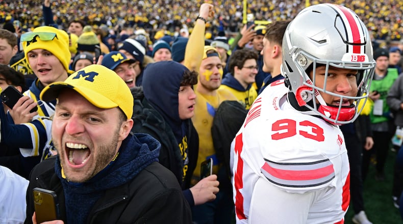 Ohio State defensive tackle Hero Kanu walks off as fans rush the field after Ohio State was defeated 30-24 by Michigan in an NCAA college football game, Saturday, Nov. 25, 2023, in Ann Arbor, Mich. (AP Photo/David Dermer)