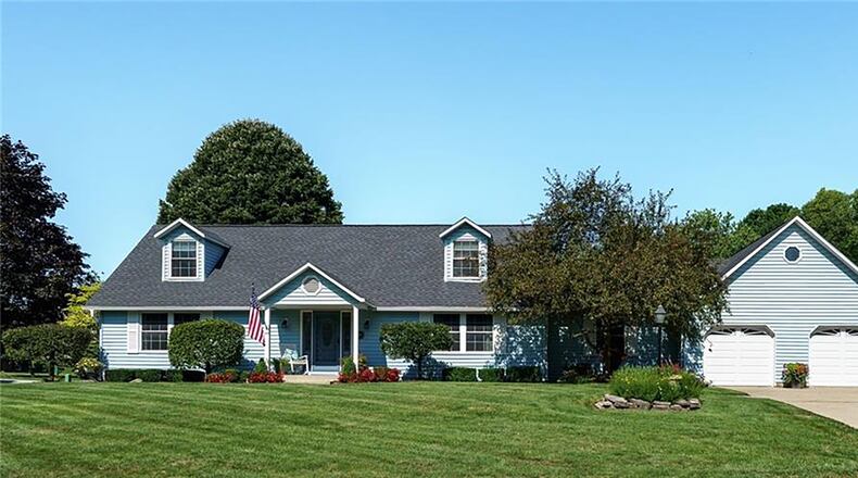 The front of the low maintenance vinyl home has a covered front porch and two dormer windows as well as a two car attached garage.