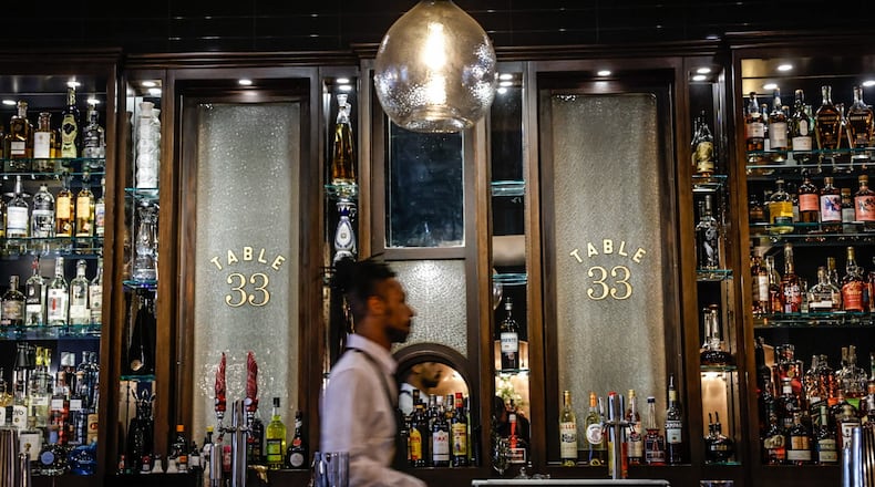 Table 33 barkeep Jalen Cambell walks through the bar at the restaurants new location at the Dayton Arcade. JIM NOELKER/STAFF