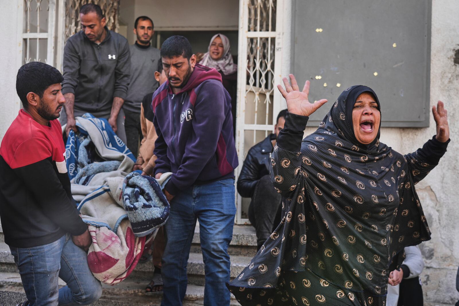 A Palestinian woman reacts as others carry the body of their relative, killed in an Israeli airstrike, in preparation for burial at Shifa Hospital in Gaza City, Wednesday, April 16, 2025. (AP Photo/Jehad Alshrafi)