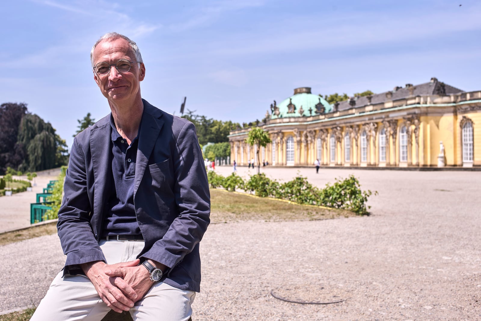 Jürgen Luh, historian of the Prussian Palaces and Gardens Foundation, poses for a portrait in front of King Frederick II of Prussia summer home Sanssouci Palace, in Potsdam, Germany, June 17, 2025. (AP Photo/Markus Schreiber)
