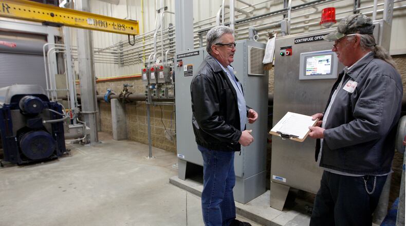 Terry Morris, Veolia Water’s project manager for the Springboro waste water treatment plant, talks with maintenance technician Rick Dalton inside the upgraded facility in 2011. FILE