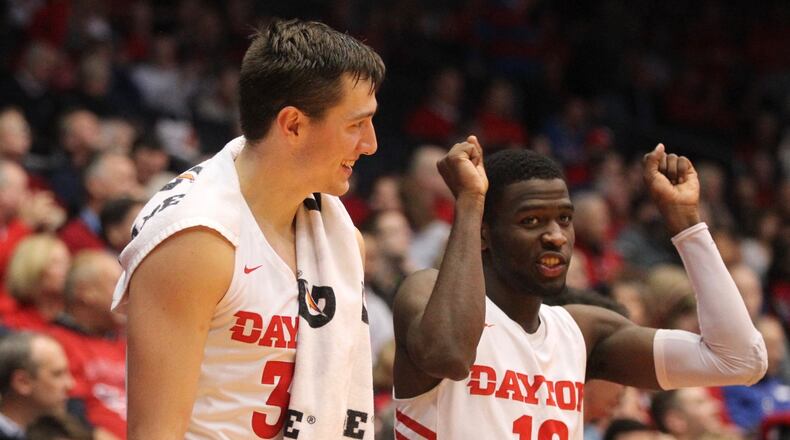 Dayton’s Ryan Mikesell, left, and Jalen Crutcher celebrate on the bench after a score against Detroit on Tuesday, Dec. 4, 2018, at UD Arena. David Jablonski/Staff