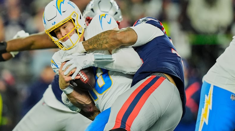 Los Angeles Chargers quarterback Justin Herbert (10) is sacked by New England Patriots linebacker Anfernee Jennings (33) in the second half of an NFL wild-card playoff football game in Foxborough, Mass., Sunday, Jan. 11, 2026. (AP Photo/Robert F. Bukaty)