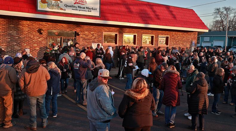 Family, friends and community members fill the parking lot of Gill's Quality Meat Market Monday, Jan. 9, 2023 during a candle light vigil for Thomas Gill, who was shot and killed Jan. 5 while driving his SUV in Springfield. BILL LACKEY/STAFF