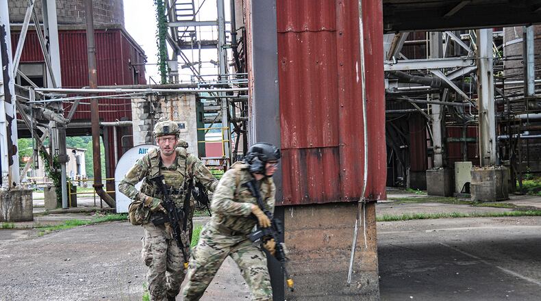 Tech. Sgt. Zachary Walker (left) and Staff Sgt. Josh Huber, 445th Security Forces Squadron, breach the outer perimeter of Albright Power Station and push forward to neutralize the fictional enemy combatant forces during a field-training exercise June 9 in West Virginia. U.S. AIR FORCE PHOTO/CAPT. RACHEL INGRAM