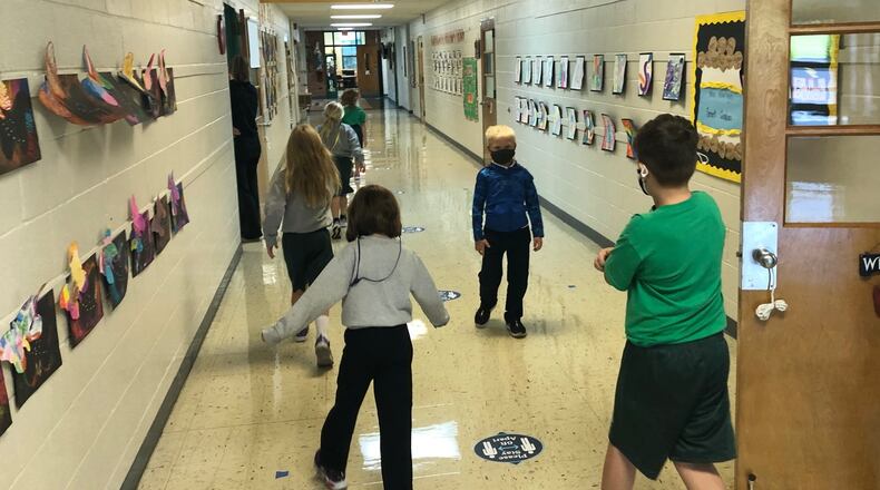 Students at St. Brigid's Catholic School in Xenia keep their distance while walking down the hall for a bathroom break Friday, Sept. 25, 2020.