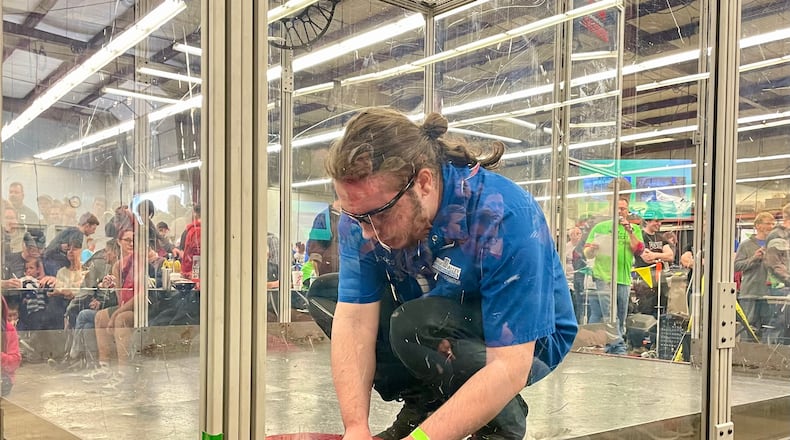 A Miami Valley Career Technology Center student prepares his bot for battle on Saturday. AIMEE HANCOCK