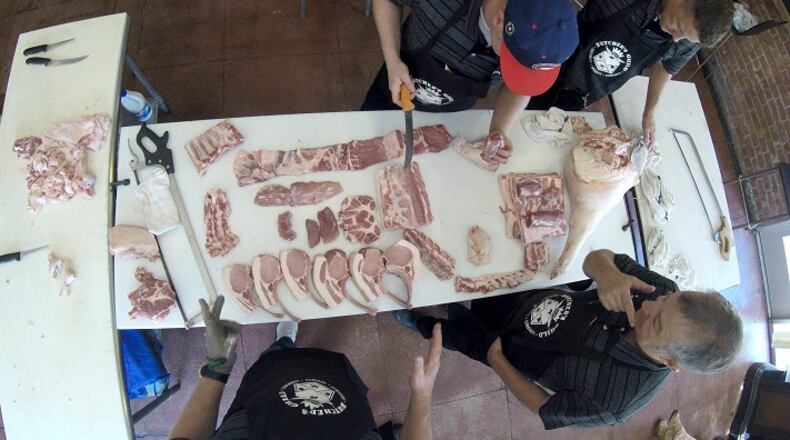Dany Johnson, bottom right, talks to members of Team USA for the World Butchers' Challenge 2018 that will be held in Belfast, Ireland as they work on a pork during a practice run at Taylor's Meat Market on Monday, Aug. 7, 2017. (Hector Amezcua/Sacramento Bee/TNS)