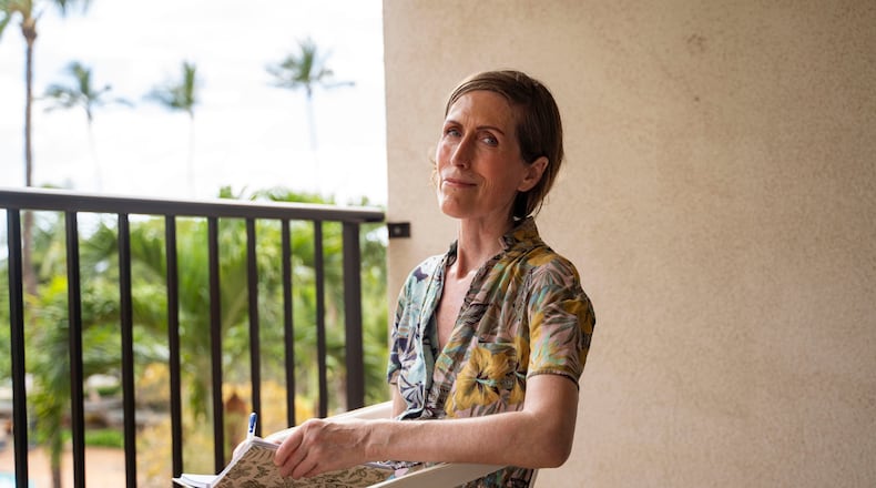Mari Younger poses for a portrait on the balcony of her converted hotel room where she lives after being displaced by the Maui fires two years prior, in Kihei, Hawaii, Wednesday, March 4, 2026. (AP Photo/Mengshin Lin)