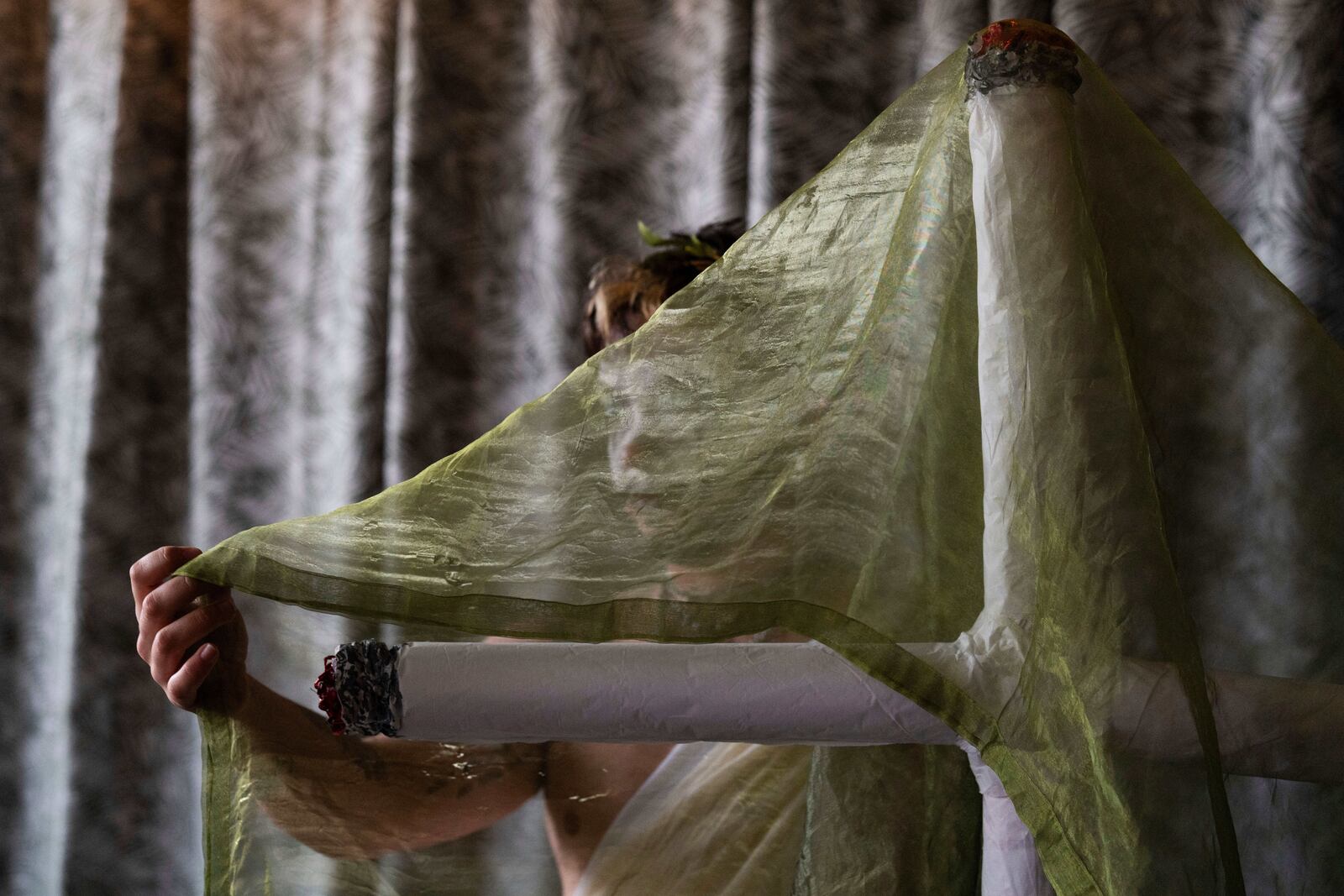 Drag performer Ed Du'Bull adjusts the green fabric on his cross made to look like lit joints after performing in a "blaze and praise" drag brunch at Bar Carlo on Sunday, April 20, 2025, in Portland, Ore. (AP Photo/Jenny Kane)