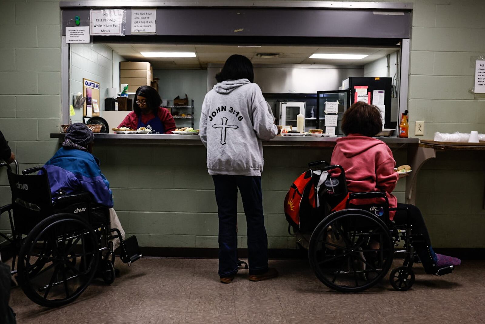 Adults line-up for dinner at the St. Vincent De Paul shelter Tuesday February 14, 2023. Many of the people who stay at the shelter have medical problems. JIM NOELKER/STAFF