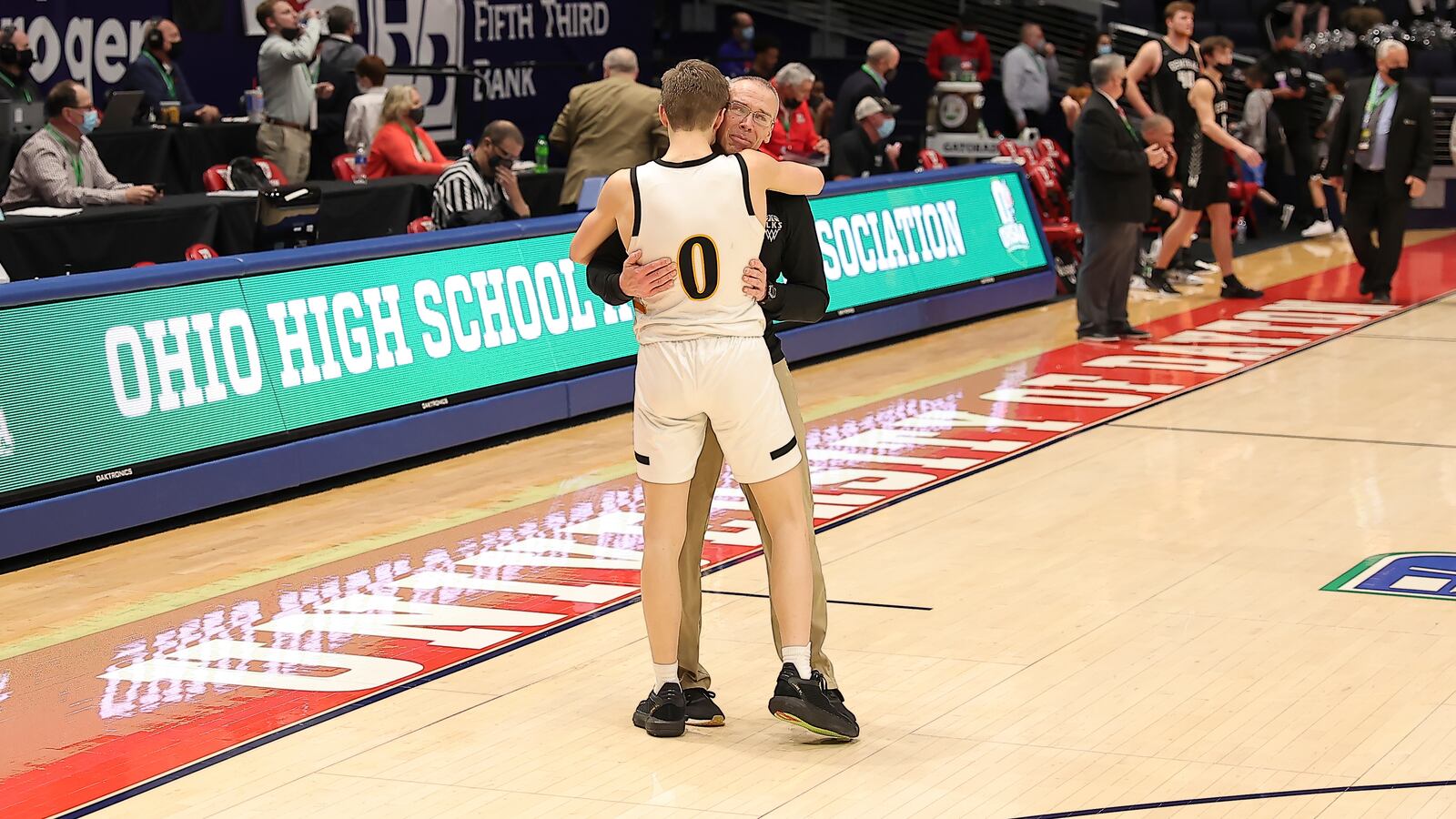 Centerville boys basketball coach Brook Cupps embraces his son, Gabe, the team's sophomore point guard, after the Elks beat Westerville Central in the D-I state championship game Sunday night at UD Arena. Michael Cooper/CONTRIBUTED