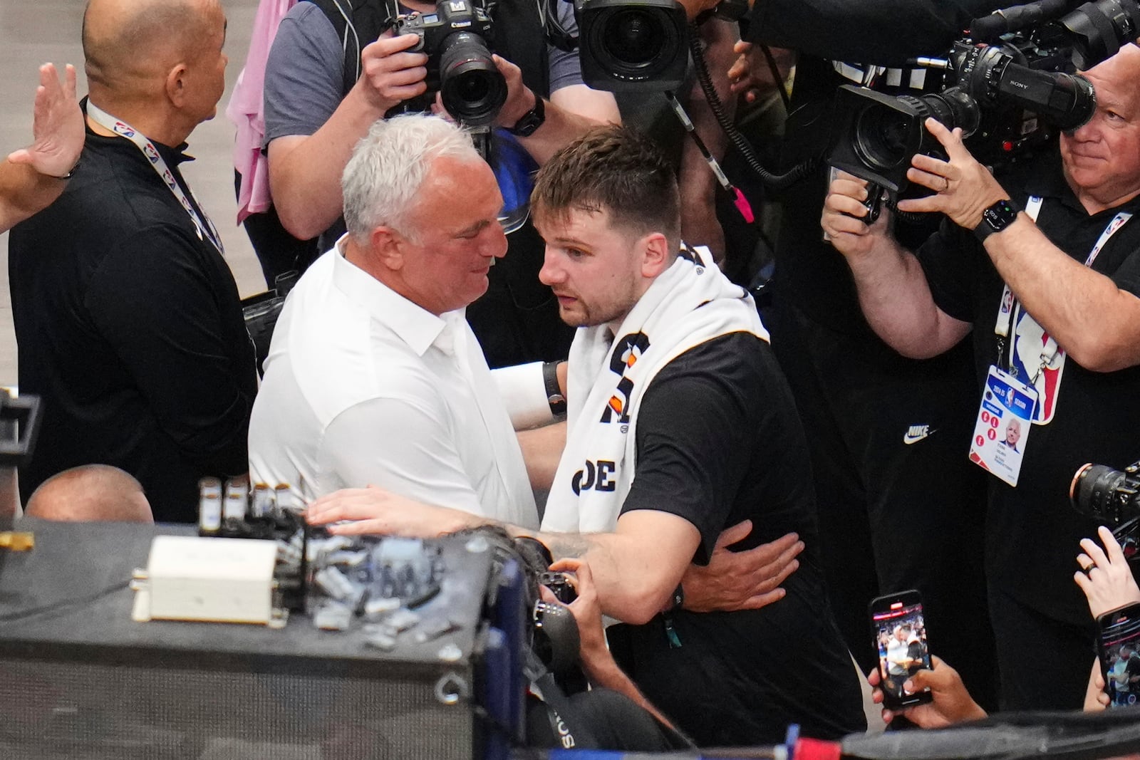 Sasa Doncic, center left in white, hugs his son, Los Angeles Lakers' Luka Doncic, center right, after the team's NBA basketball game against the Dallas Mavericks in Dallas, Wednesday, April 9, 2025. (AP Photo/Julio Cortez)