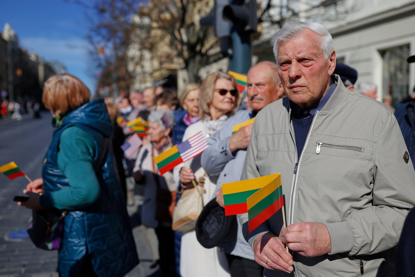 People with U.S. and Lithuanian national flags attend a solemn farewell ceremony at Cathedral Square in Vilnius, Lithuania, Thursday, April 3, 2025 for the US soldiers who died during training exercise. (AP Photo/Mindaugas Kulbis)
