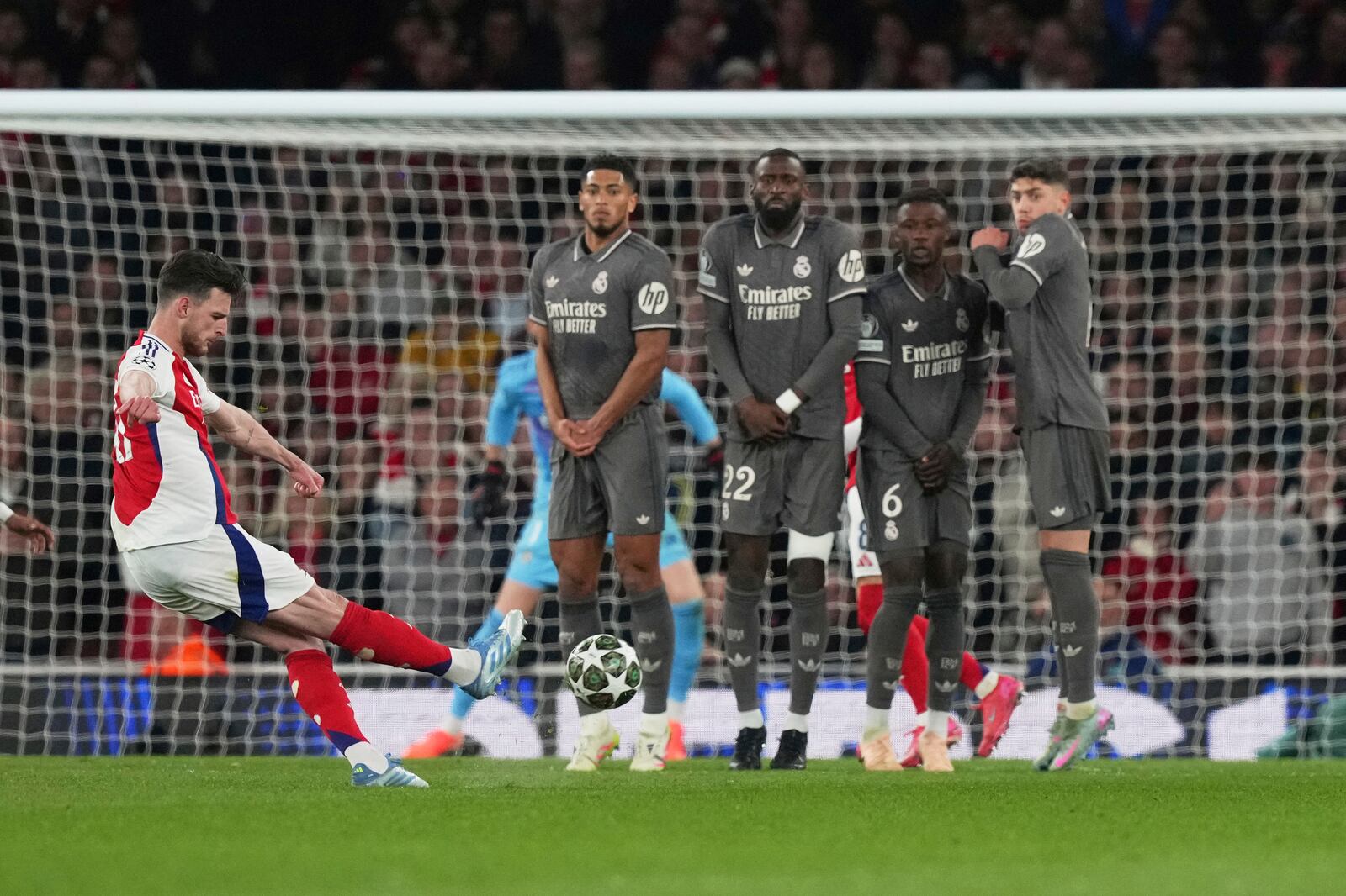 Arsenal's Declan Rice, left, scores his side's opening goal during the Champions League quarterfinal first leg soccer match between Arsenal and Real Madrid at the Emirates Stadium in London, Tuesday, April 8, 2025. (AP Photo/Frank Augstein)