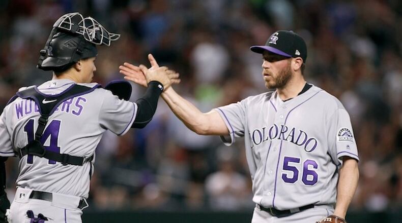 Colorado Rockies' Greg Holland (56) is congratulated by Tony Wolters after pitching the ninth inning against the Arizona Diamondbacks during a baseball game, Saturday, April 29, 2017, in Phoenix. The Rockies won 7-6. (AP Photo/Ralph Freso)