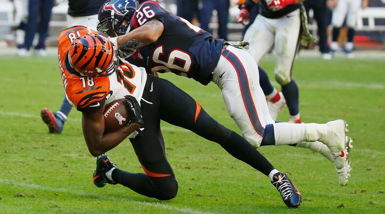 HOUSTON, TX - NOVEMBER 23: A.J. Green #18 of the Cincinnati Bengals is tackled by Darryl Morris #26 of the Houston Texans in the first half of their game at NRG Stadium on November 23, 2014 in Houston, Texas. (Photo by Scott Halleran/Getty Images)