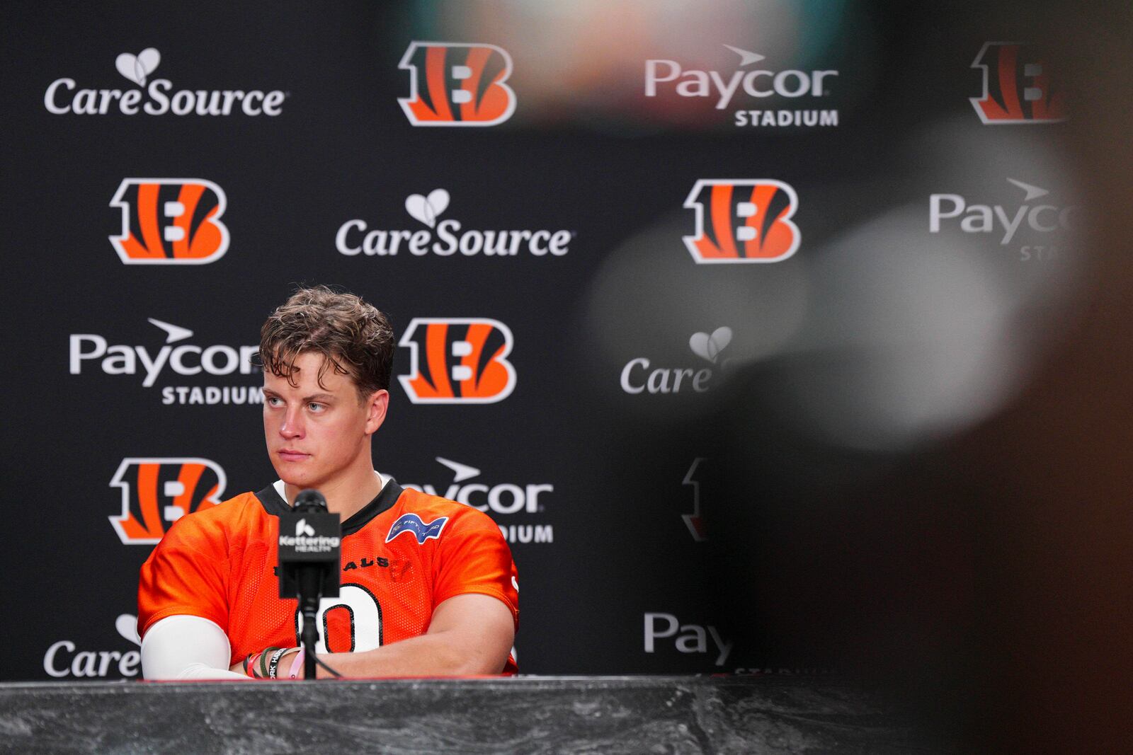Cincinnati Bengals' Joe Burrow (9) listens during a press conference following practice at the team's NFL football training camp, Wednesday, July 23, 2025, in Cincinnati. (AP Photo/Jeff Dean)