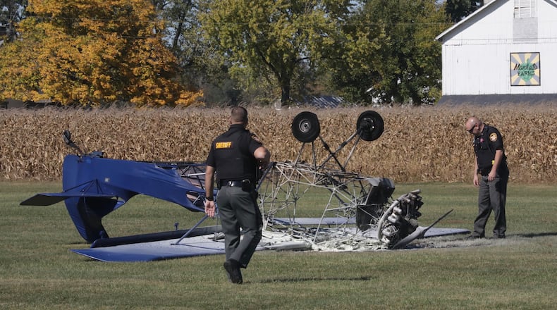 Clark County Sheriff’s deputies look over the remains of an airplane that crashed and burst into flames on the runway Tuesday, Oct. 13, 2020, at the Andy Barnhart Memorial Airport in New Carlisle. BILL LACKEY/STAFF