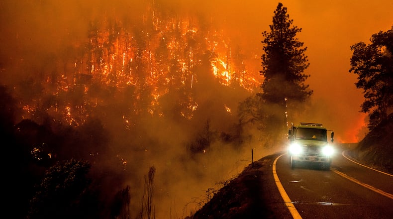 FILE - A firetruck drives along California Highway 96 as the McKinney Fire burns in Klamath National Forest, Calif., on July 30, 2022. (AP Photo/Noah Berger, File)
