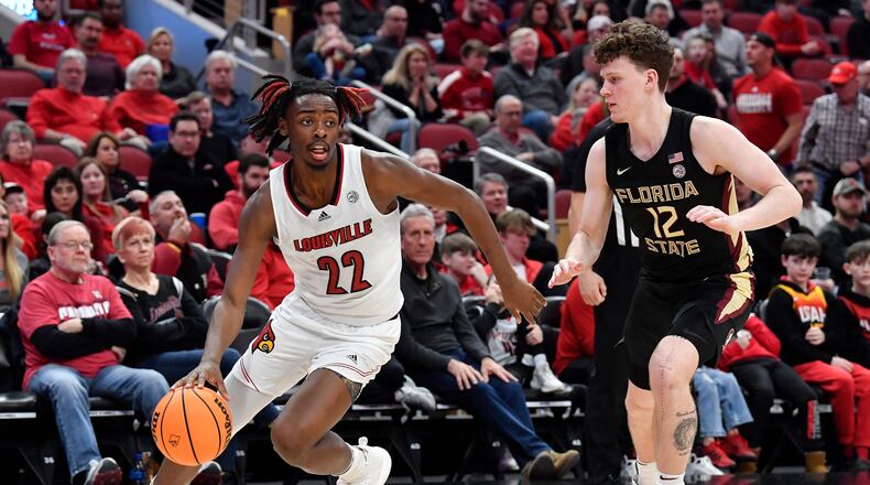 Louisville forward Kamari Lands (22) drives past Florida State guard Tom House (12) during the second half of an NCAA college basketball game in Louisville, Ky., Saturday, Feb. 4, 2023. (AP Photo/Timothy D. Easley)