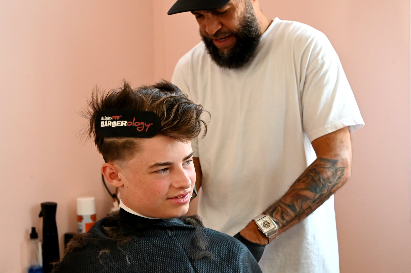 Hue Mane Salon on Pleasant Avenue held a back-to-school hair-cutting event where parents could "Pay What You Can" to get their kids new haircuts ahead of the new school year, which started the week of Aug. 11, 2025, for the Hamilton City School District. Stylists from other salons and Hue Mane participated in the event, which included multiple vendor booths, including Lane Libraries, SELF and Sunrise Treatment Center. Pictured is Emory Jones, 14, who attends Hamilton Freshman School, getting his hair cut by Perfectly Blended barber David Smith, who volunteered for the event. MICHAEL D. PITMAN/STAFF