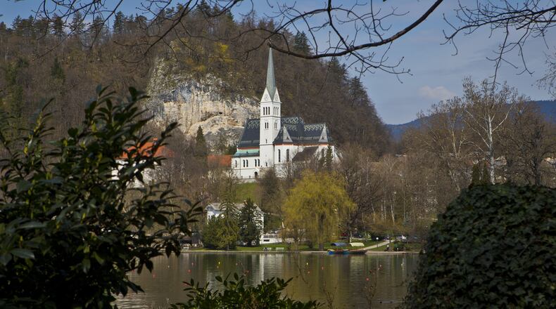 In this April 16, 2013 photo, a church is seen on the shore of Lake Bled, northern Slovenia. It was at the lakeside Grand Hotel Toplice in Bled where Melanija Knavs, who later changed her name to Melania Knauss, introduced Donald Trump to her parents during their brief visit to Slovenia in July 2002, two years before they engaged. It is believed that it was the last time that the former model visited her native country. (AP Photo/Darko Bandic)