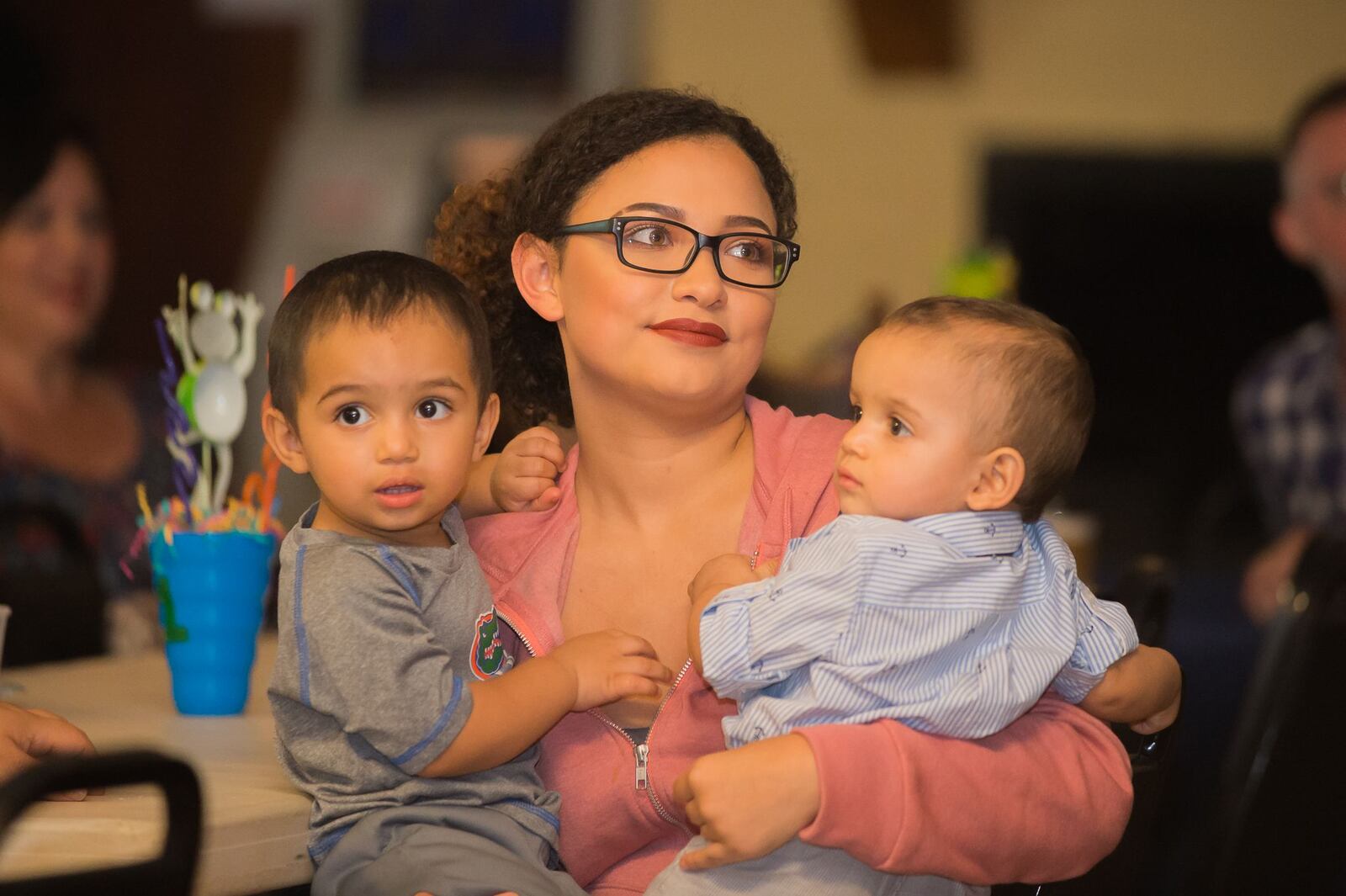 Cousin Danna Paola Lasso Nino holds Juan Pedro and Guillermo Timoteo Nino-Brown Sunday, July 29, 2018 in American Legion Hall during the boys' birthday celebration and fundraiser.