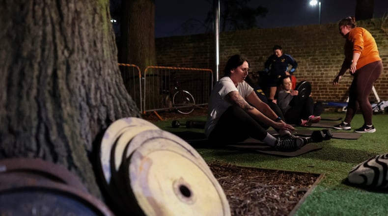 FILE - Chloe Spriggs, left, takes a moment as members of Teddington women's rugby team use weights as they train at the club house in Bushy Park in London, Thursday, Jan. 16, 2025. (AP Photo/Charlotte Coney,File)b