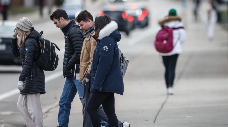 Students, workers and residents walk around Brown Street near the University of Dayton campus Wednesday afternoon Jan. 12, 2022. JIM NOELKER/STAFF