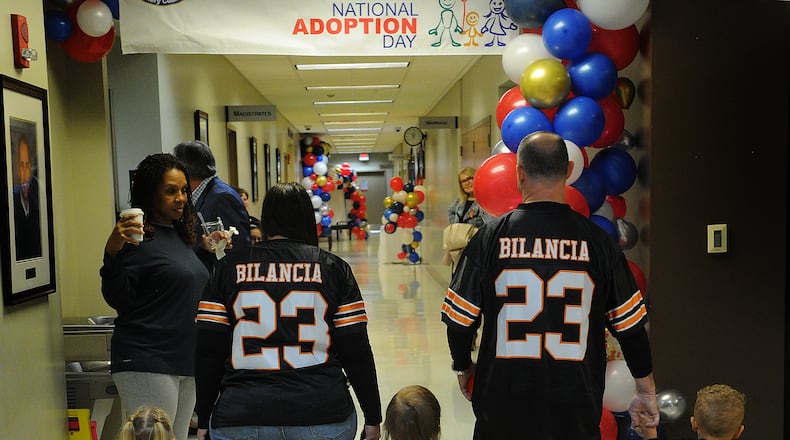 The Bilancias walk down the Montgomery County courthouse hall after finalizing the adoption of their three children on Thursday, Nov. 16, 2023. MARSHALL GORBY\STAFF