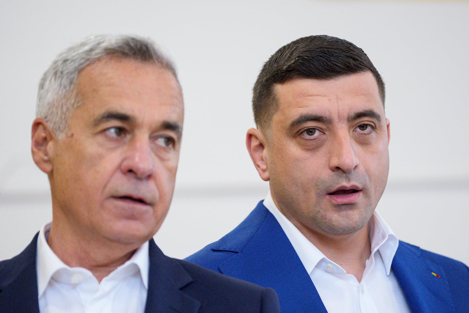 Presidential candidate George Simion, right, and Calin Georgescu, winner of the first round of last year's annulled election, speak to the media after casting their votes in the second round of the country's presidential election redo in Mogosoaia, Romania, Sunday, May 18, 2025. (AP Photo/Andreea Alexandru)