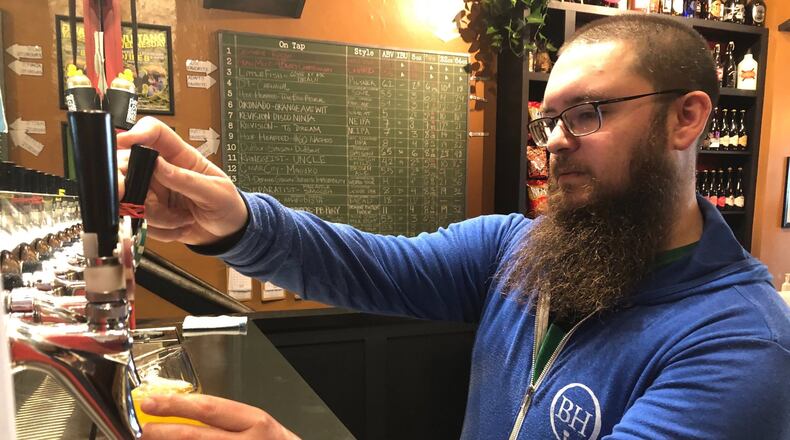 Gus Stathes, co-owner of The Barrel House at 417 E. Third St., pours a craft beer Sunday afternoon in downtown Dayton. Stathes said an extended forced shutdown due to the coronavirus could doom his business, although he sees why it might be necessary.